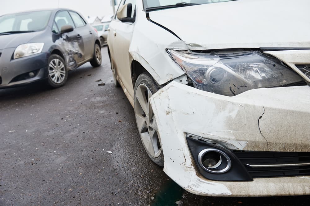 City street aftermath: Wrecked cars after collision. Scene of a car crash with damaged vehicles on the road.