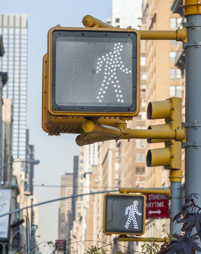 Urban street lamp illuminating the pathway with a warm glow, enhancing cityscape ambiance and pedestrian safety.