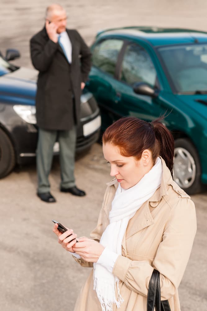 Woman contacting insurance following car accident with man.